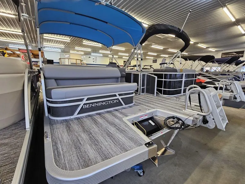Slide: The Image of 2025 Bennington 22SLJ pontoon boat with blue canopy in showroom. - 10