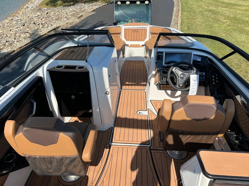 Slide: The Image of 2025 Yamaha Boats 252SD interior with brown seating and modern dashboard. - 11