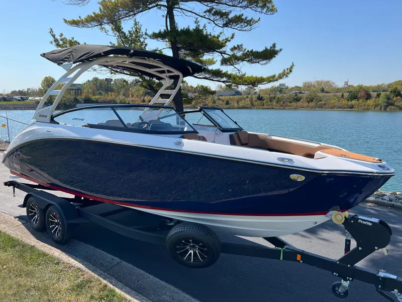 Slide: The Image of 2025 Yamaha Boats 252SD on trailer by a scenic lake. - 2