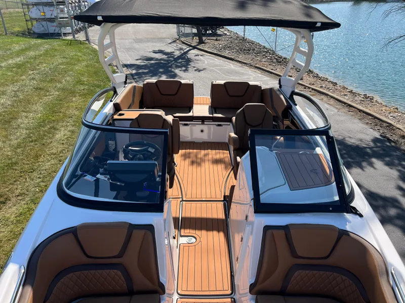Slide: The Image of 2025 Yamaha Boats 252SD with sleek interior and spacious seating by the water. - 23