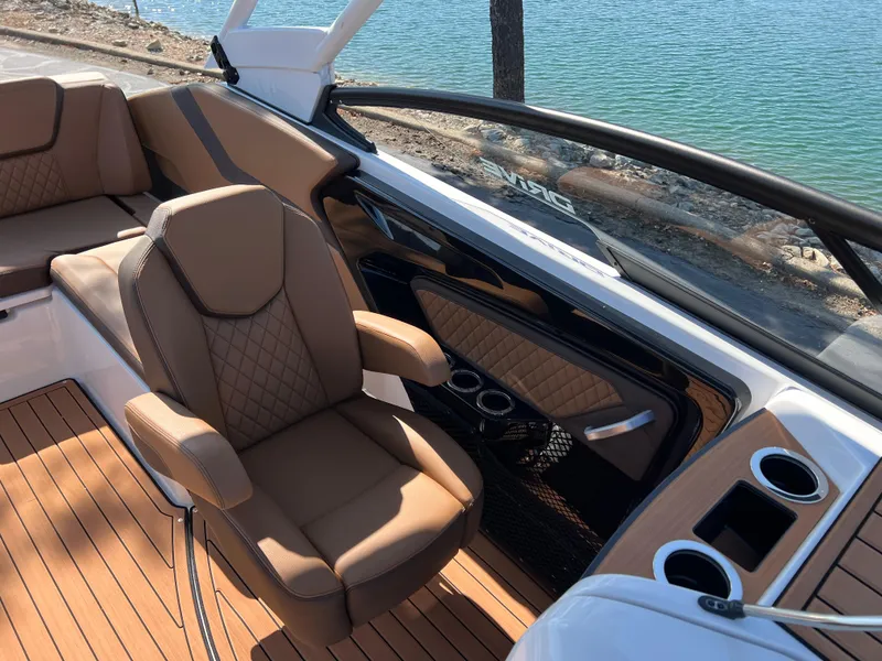 Slide: The Image of Luxurious interior of 2025 Yamaha Boats 252SD with tan seating and wood flooring. - 25