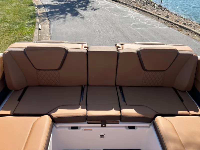 Slide: The Image of 2025 Yamaha Boats 252SD interior seating, tan upholstery, near water. - 29