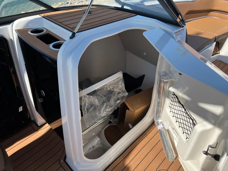 Slide: The Image of 2025 Yamaha Boats 252SD interior cabin with open door, showcasing storage and seating. - 35