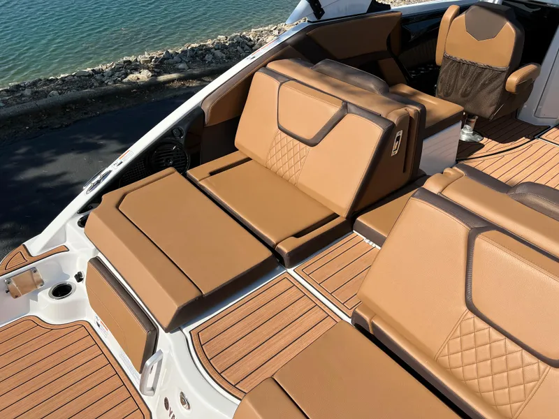Slide: The Image of 2025 Yamaha Boats 252SD with luxurious tan seating and elegant design by the water. - 7