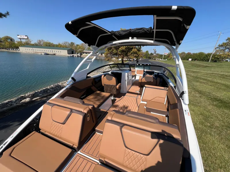 Slide: The Image of 2025 Yamaha Boats 252SD with luxurious seating and sleek design by the water. - 8