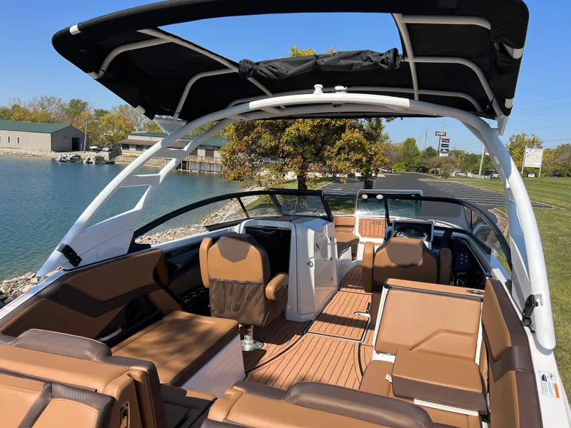 Slide: The Image of 2025 Yamaha Boats 252SD interior with tan seating and sleek design by the water. - 9