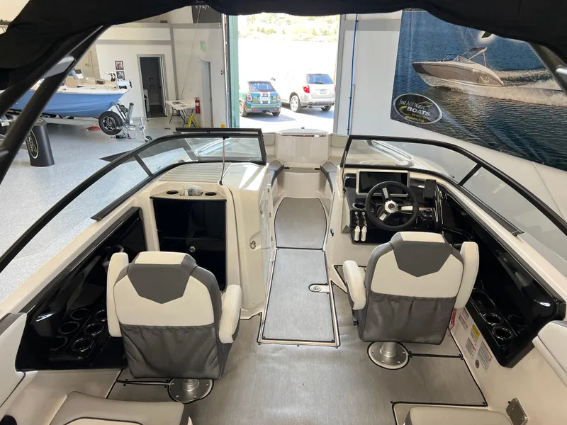 Slide: The Image of 2025 Yamaha Boats AR250 interior with modern seating and dashboard in showroom. - 6