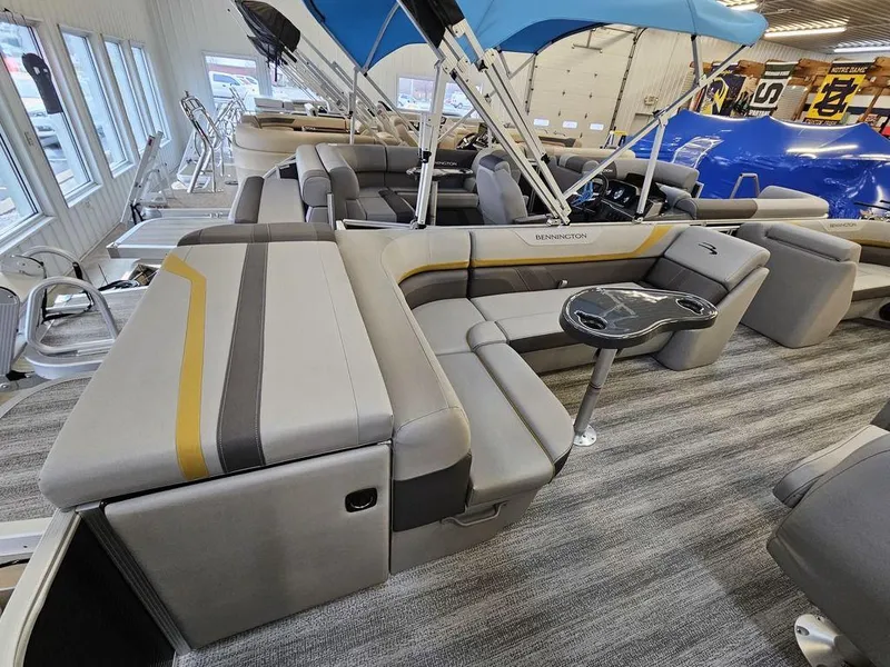 Slide: The Image of 2025 Bennington 22 SXL pontoon boat interior with gray seating and blue canopy. - 5