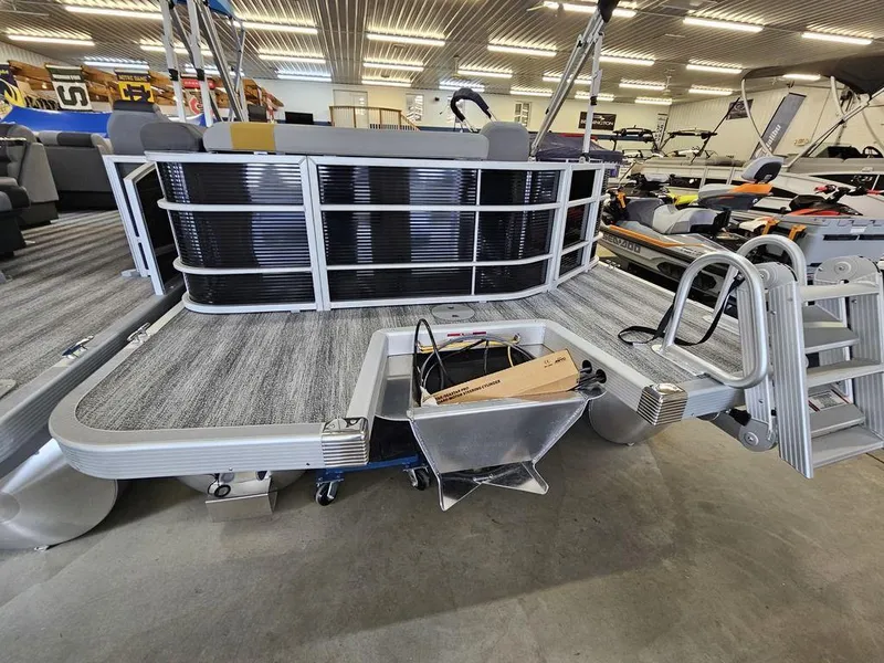 Slide: The Image of 2025 Bennington 22 SXL pontoon boat in showroom, rear view with ladder and deck. - 8