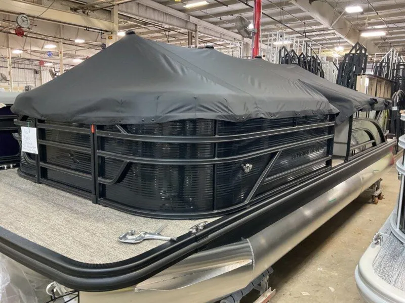 Slide: The Image of 2025 Bennington 23 SL pontoon boat with black cover in a showroom. - 17