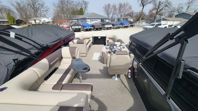 Slide: The Image of 2025 Bennington 23 SL pontoon boat interior with beige seating and steering console. - 19