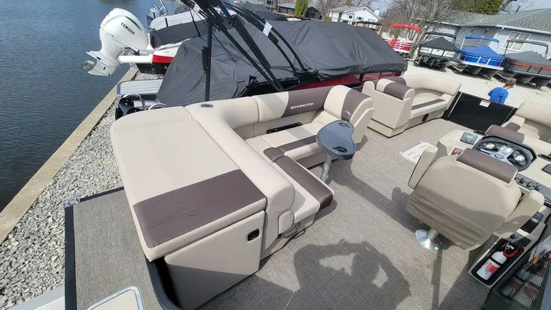 Slide: The Image of 2025 Bennington 23 SL pontoon boat with spacious seating and modern design docked by the water. - 20