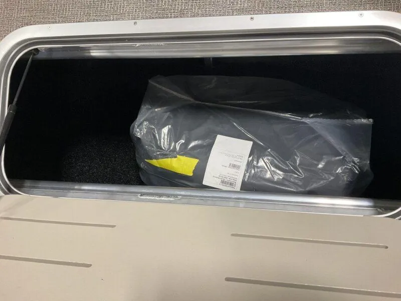Slide: The Image of Storage compartment in a 2025 Bennington 23 SL boat with packaged item inside. - 23