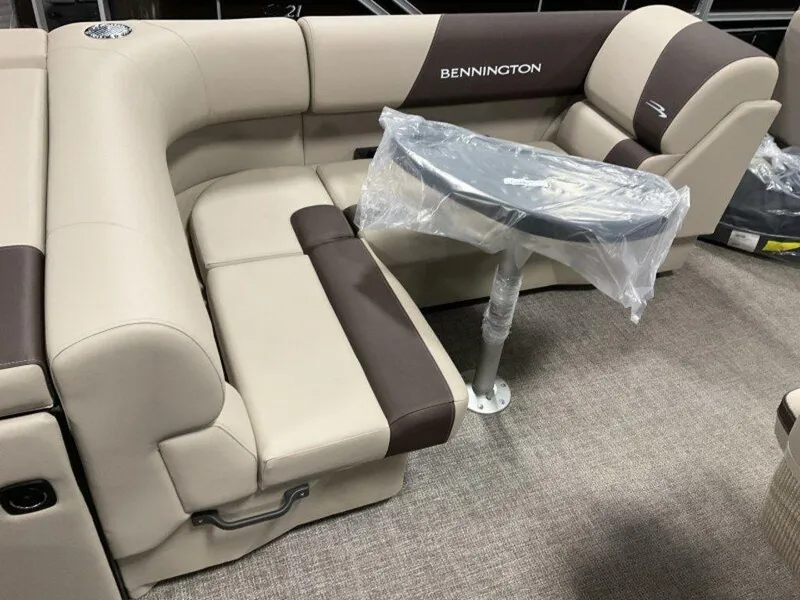 Slide: The Image of 2025 Bennington 23 SL boat interior with beige and brown seating, small table. - 7