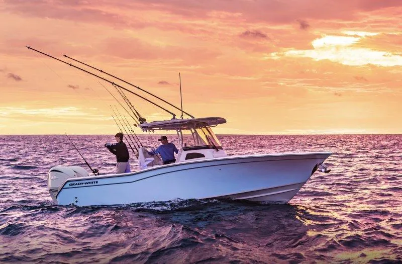 Slide: The Image of 2025 Grady-White Canyon 271 boat at sunset, two people fishing on open water. - 1