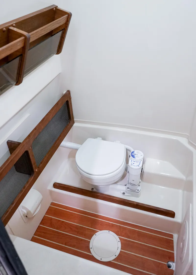 Slide: The Image of 2025 Grady-White Canyon 271 boat bathroom with wooden accents and modern fixtures. - 13