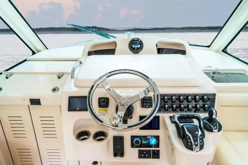 Slide: The Image of 2025 Grady-White 330 Express boat helm with modern controls and steering wheel. - 2