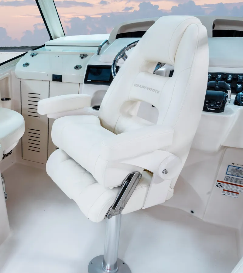 Slide: The Image of Captain's chair in 2025 Grady-White 330 Express boat cockpit, featuring modern controls and design. - 3