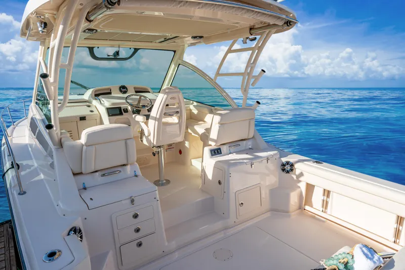 Slide: The Image of 2025 Grady-White 330 Express boat interior with ocean view, featuring helm and seating area. - 4