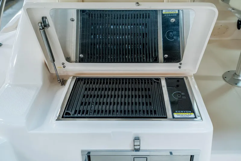 Slide: The Image of Built-in grill on 2025 Grady-White 330 Express boat, featuring Kenyon electric cooktop. - 6