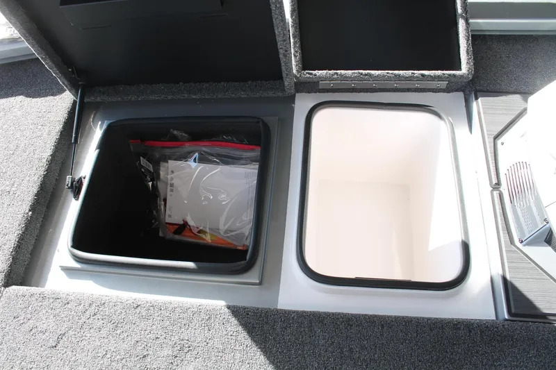 Slide: The Image of 2025 Vexus AVX1880 boat storage compartments, open with visible contents. - 16