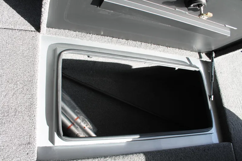 Slide: The Image of Open storage compartment in 2025 Vexus AVX1880 boat, featuring carpeted interior. - 17