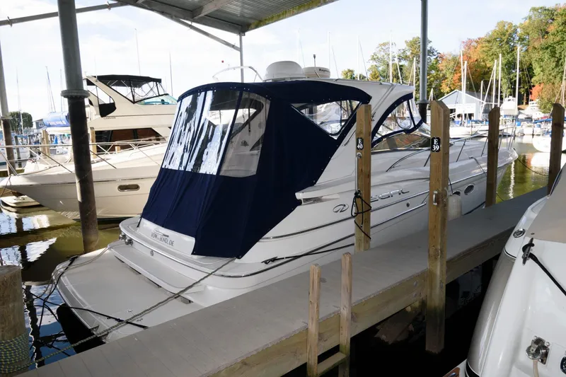The Image of 2006 Regal 4460 Commodore yacht docked in a marina under a covered shelter. - 0