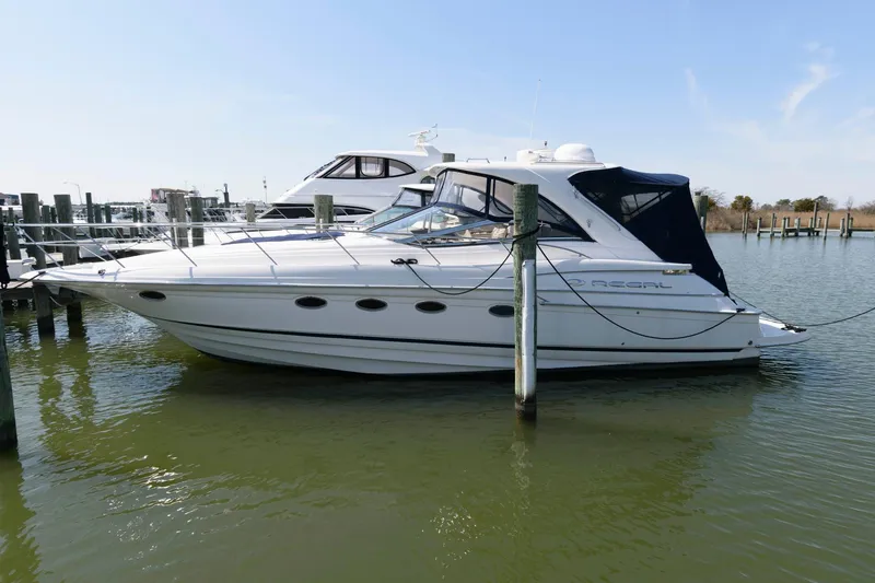 Slide: The Image of 2006 Regal 4460 Commodore yacht docked in a marina, side view. - 2