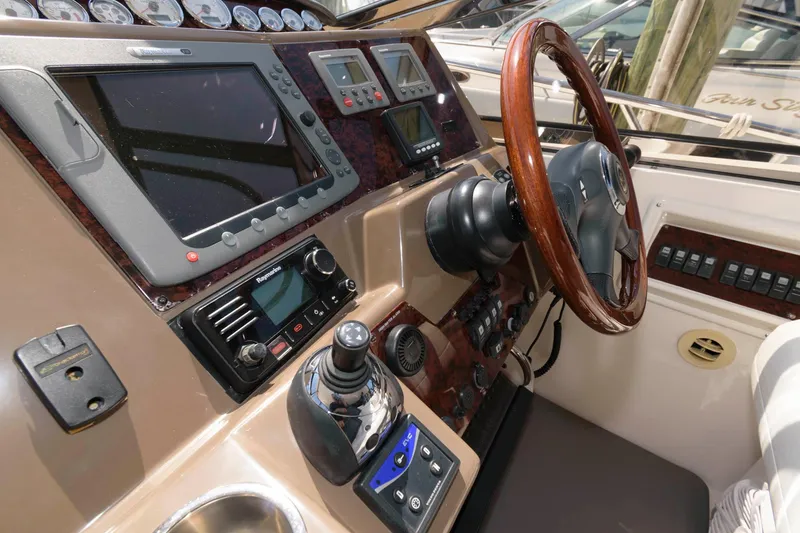 Slide: The Image of 2006 Regal 4460 Commodore helm with wood steering wheel and advanced navigation controls. - 7