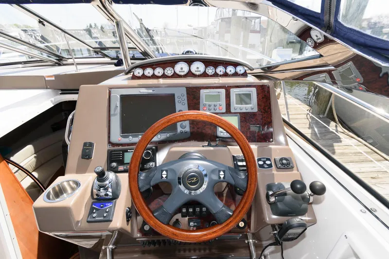 Slide: The Image of 2006 Regal 4460 Commodore helm with wood steering wheel and advanced navigation instruments. - 8