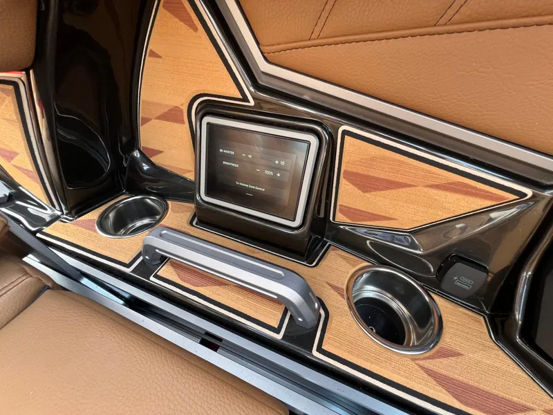 Slide: The Image of 2025 Tigé 25ZX Ultre' boat interior with touchscreen, cup holders, and wood accents. - 17