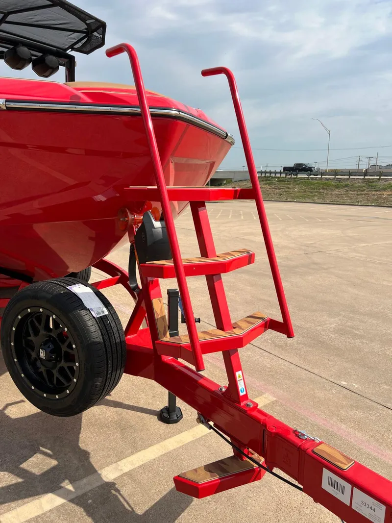 Slide: The Image of Red 2025 Tigé 25ZX Ultre' boat on trailer with ladder and spare tire. - 5