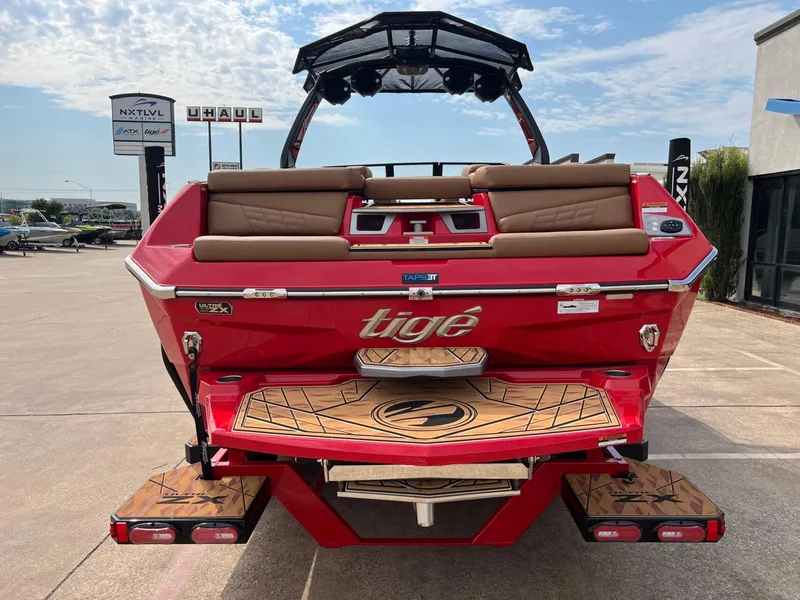 Slide: The Image of 2025 Tigé 25ZX Ultre' boat, red exterior, rear view with seating and swim platform. - 6