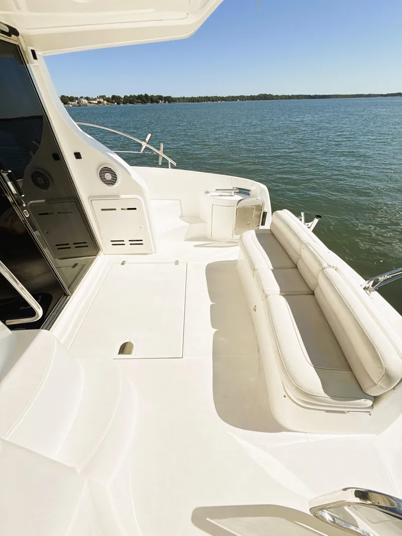 Slide: The Image of 2002 Azimut 42 yacht deck with white seating, overlooking calm waters. - 20