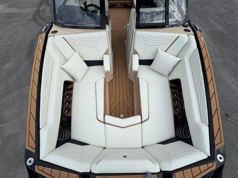 Slide: The Image of 2025 Nautique G25 boat interior with white seating and wood accents. - 11