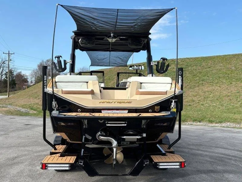 Slide: The Image of 2025 Nautique G25 boat rear view with canopy and seating. - 121