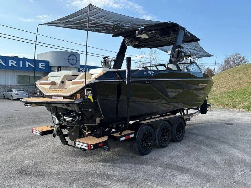 Slide: The Image of 2025 Nautique G25 boat on trailer, parked outdoors near marine dealership. - 123