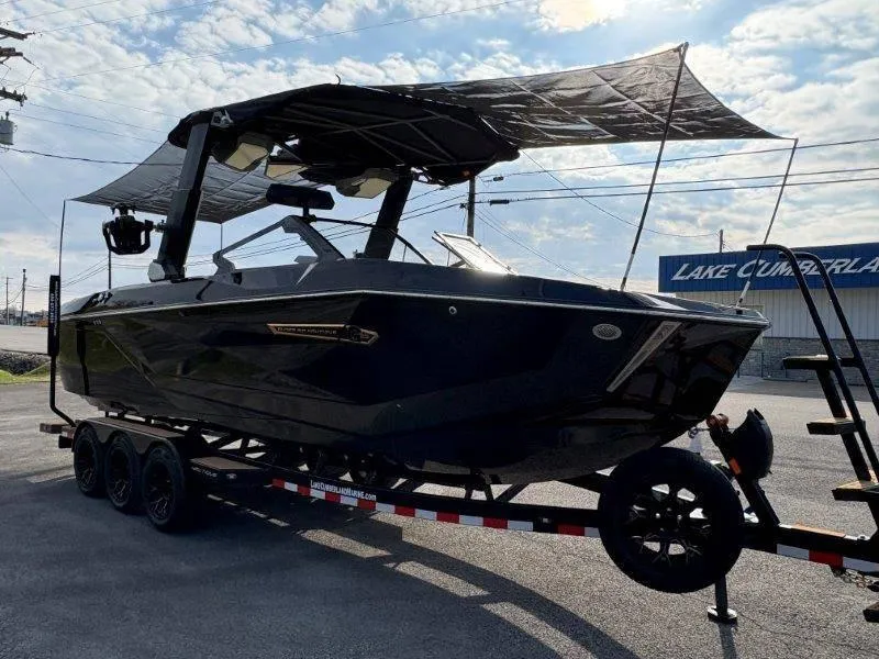 Slide: The Image of 2025 Nautique G25 boat on trailer with canopy, parked near Lake Cumberland. - 127