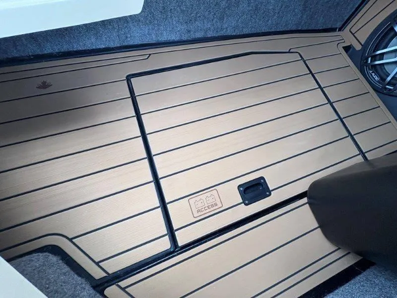 Slide: The Image of 2025 Nautique G25 boat interior with sleek wooden flooring and access panel. - 134