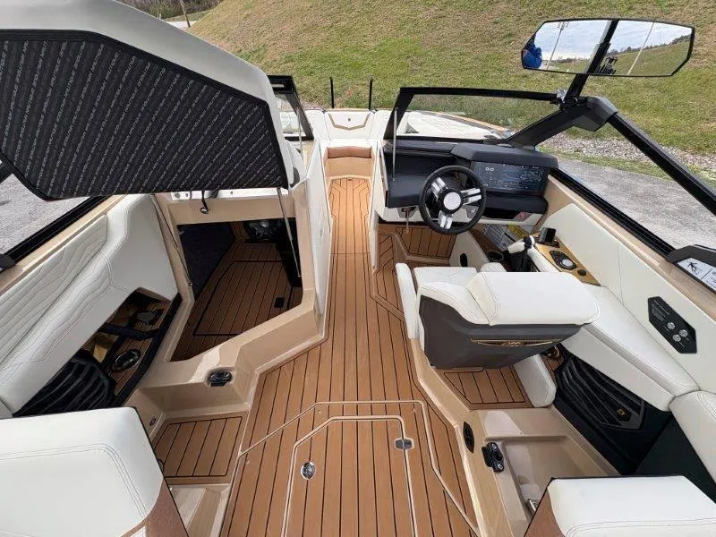 Slide: The Image of Interior of 2025 Nautique G25 boat with luxurious seating and modern dashboard. - 14
