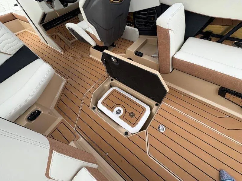 Slide: The Image of 2025 Nautique G25 boat interior with open storage compartment and luxurious seating. - 16