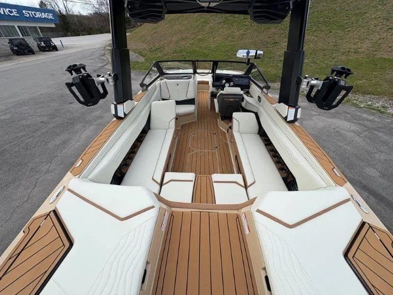 Slide: The Image of 2025 Nautique G25 boat interior with luxurious seating and teak flooring. - 23
