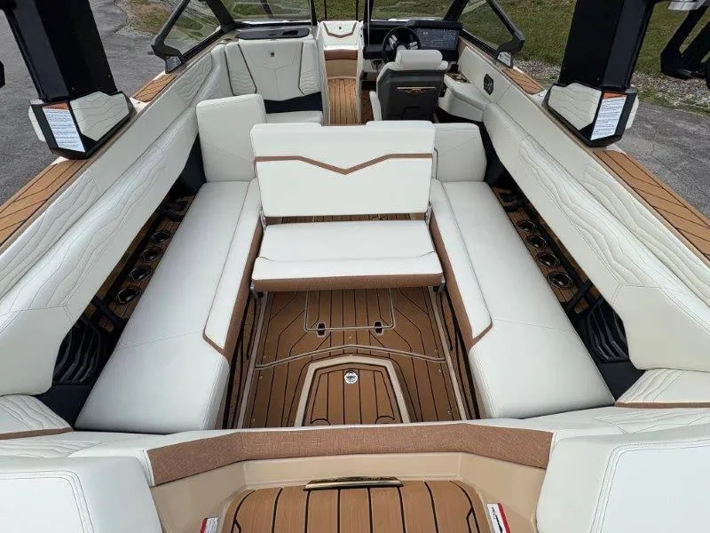 Slide: The Image of 2025 Nautique G25 boat interior with white seating and teak flooring. - 25