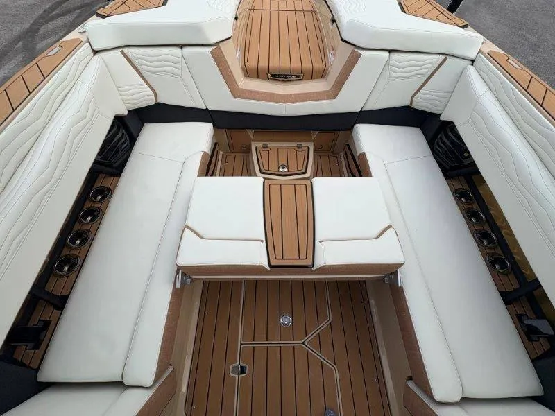 Slide: The Image of 2025 Nautique G25 boat interior with luxurious seating and teak flooring. - 28