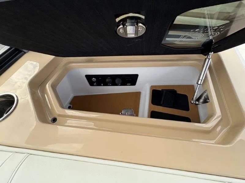 Slide: The Image of 2025 Nautique G25 storage compartment with control panel and hydraulic lift. - 30