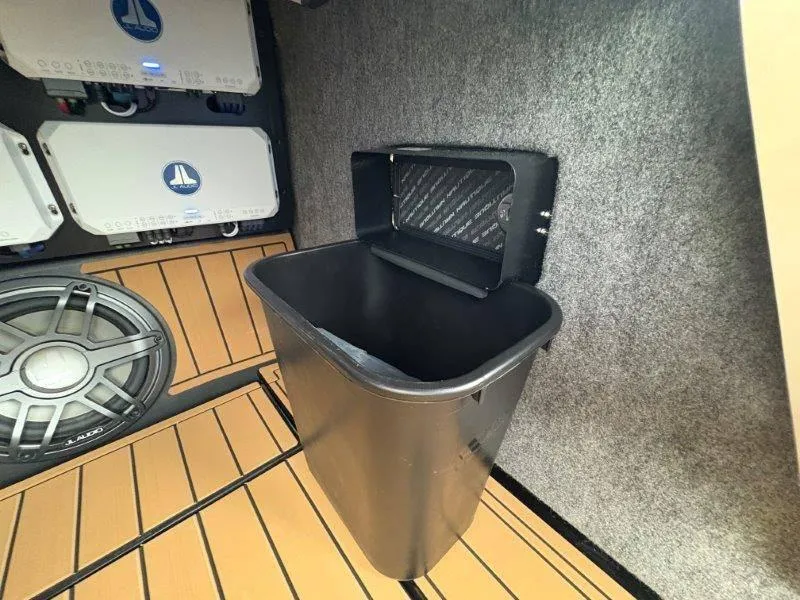 Slide: The Image of 2025 Nautique G25 interior with sound system and trash bin. - 32