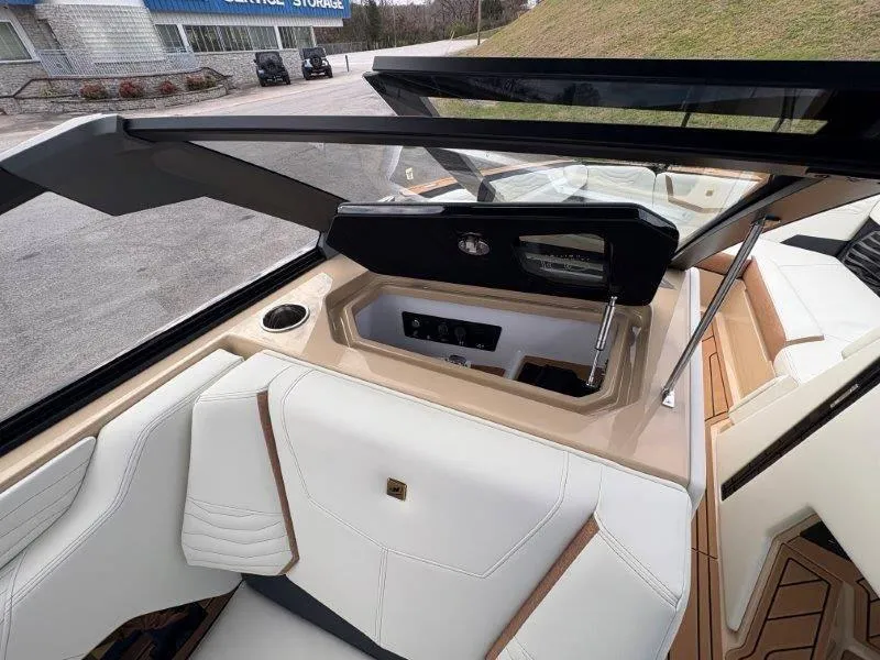 Slide: The Image of Interior of 2025 Nautique G25 boat with white seating and modern dashboard. - 33