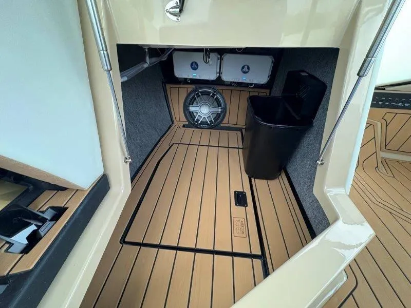 Slide: The Image of 2025 Nautique G25 boat interior with wood flooring and speaker system. - 35
