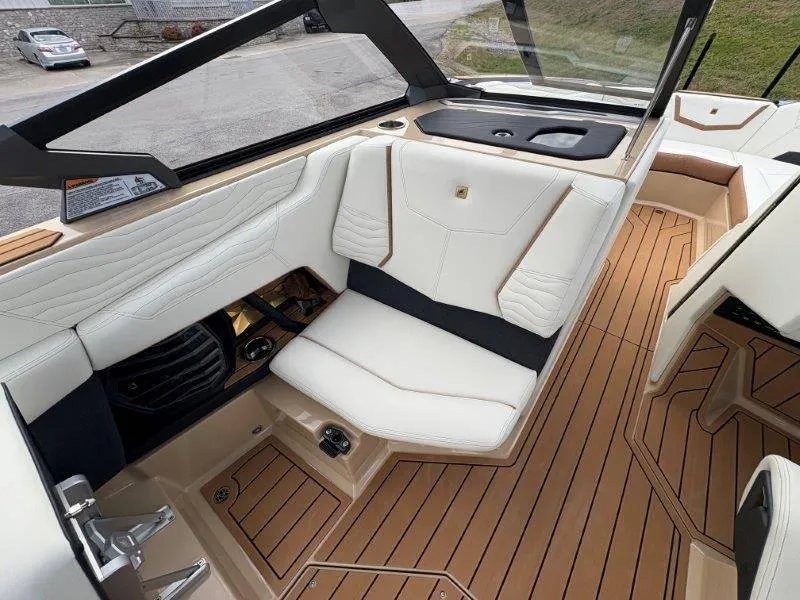 Slide: The Image of 2025 Nautique G25 boat interior with white seating and teak flooring. - 40