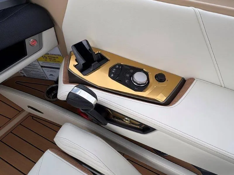 Slide: The Image of 2025 Nautique G25 boat control panel with gold accents and modern design. - 47